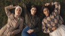 Three models wearing Muzdan autumn looks in earthy tones